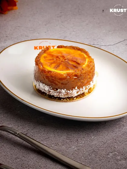 A beautifully plated Orange Ginger Tea Cake, ready to be served. The combination of zesty orange and spicy ginger is the perfect companion for a cup of tea or coffee.
