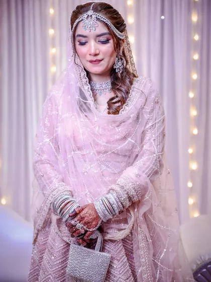 A full-length shot of this bride in her shimmering pink lehenga. She looks like a princess.