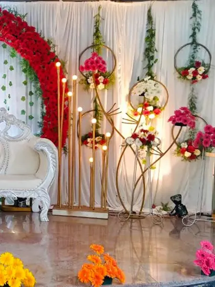A slightly different angle of the classic wedding stage with a red floral arch.