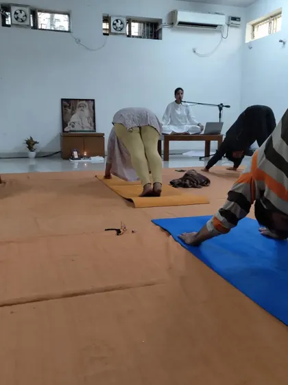 Participants hold the downward-facing dog posture, a key part of the Surya Kriya flow.
