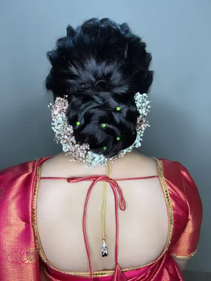 A full view of the simple twisted bun, showing how the baby's breath creates a soft, cloud-like effect around the hairstyle. It's a romantic and modern choice for any pre-wedding celebration.