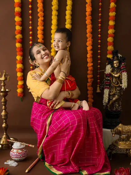 A beautiful, candid moment of a mother lifting her son, both laughing and enjoying the festive shoot.