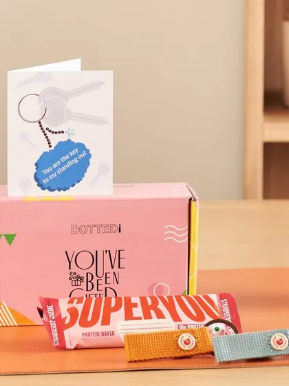 A charming gift set for a teacher with a "key to my standing out" theme, featuring cute keychains and a protein bar in a "You've Been Gifted" box.