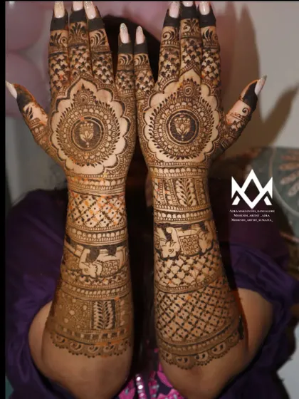 This bridal design features a central mandala on the palm with detailed work extending up the arm, a classic and popular choice for brides.