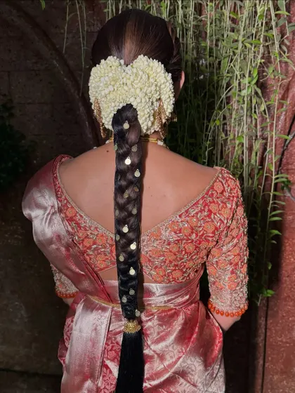 This view showcases the beautiful symmetry of the heart-shaped jasmine veni and the neatness of the traditional braid. It's a timeless look for any bride.