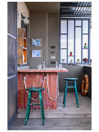 The "Sailor's Bar" on the terrace, featuring a rustic, distressed red bar, teal stools, and a lifebuoy for a fun, nautical theme.