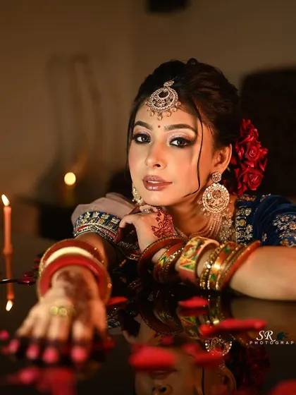 This candlelit portrait creates a warm and intimate mood, highlighting the bride's glowing makeup and jewelry.