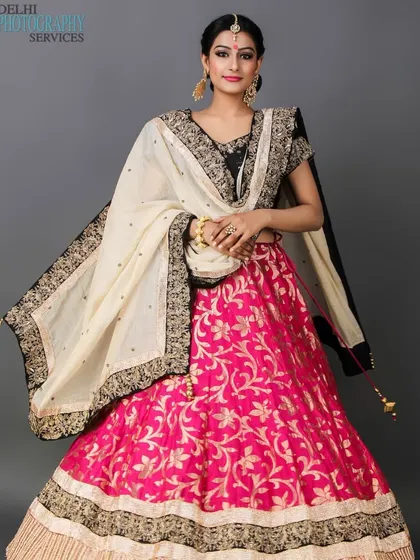 I create stunning portfolios for ethnic wear, capturing the richness of traditional Indian attire. This full-length shot features a model in a vibrant pink and black lehenga, showcasing the intricate details and flow of the garment for bridal or festive lookbooks.