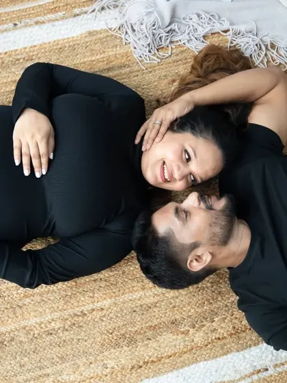 A relaxed and intimate moment. Lying on a rustic jute rug, this couple shares a loving gaze, a beautiful way to capture a more casual maternity portrait.
