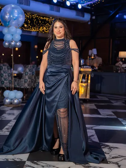 Another stunning gown from our collection, this one in a deep navy blue with a satin trail and beaded bodice. It’s the epitome of cocktail glamour.