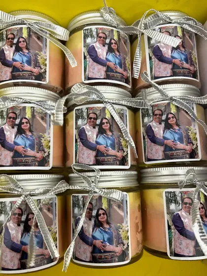A box full of the custom photo-labeled candles, ready for a silver jubilee celebration.
