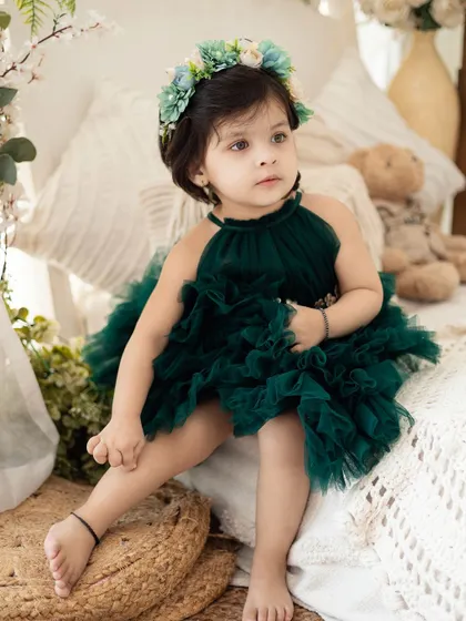 A little princess in a stunning dark green ruffled dress. We have a variety of high-end, beautiful outfits for your child's photoshoot.