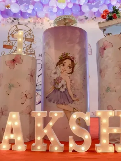 Custom-printed plinths for Sakshi's butterfly-themed birthday. The marquee letters spelling out her name add a personalized and glowing touch to the decor.