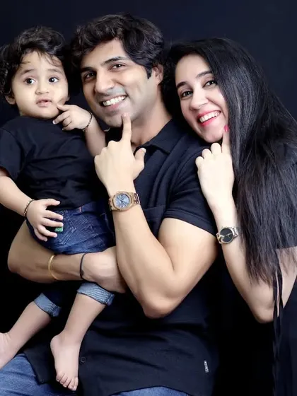 A modern and stylish studio family portrait against a simple black background. This classic setup puts all the focus on the family's connection and joyful expressions.