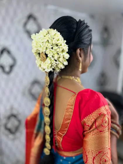 The hairstyle for the South Indian look, featuring a traditional braid adorned with jasmine flowers.