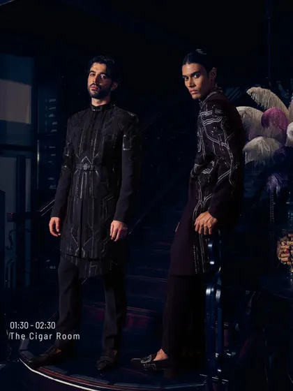 Two silhouettes sculpted in noir. These are the after-dark armors of modern royals, featuring sharp cuts, heavy shoulders, and the softened sheen of velvet. They are not just in the moment; they are the afterparty.