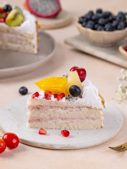 A light and airy slice of fresh fruit cake, with layers of cream and fruit, styled to look fresh and delicious.