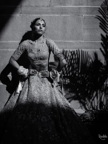 A striking black and white bridal portrait of Amala. The harsh sunlight and palm shadows at Umaid Bhawan create a dramatic, high-fashion look.