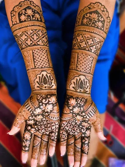 This traditional bridal mehndi is filled with classic elements. It features bands of lotus motifs and jaali patterns, creating a design that is both intricate and timeless.
