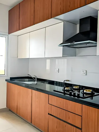 A simple yet elegant straight-line kitchen combining light wood base cabinets with clean white upper cabinets. The black granite countertop and built-in hob make this a practical and stylish solution, especially for smaller kitchen layouts.