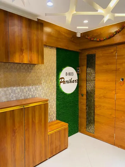 An entrance designed for the Parihar family. We used a combination of wood laminate, a vertical garden panel, and a circular nameplate to create a fresh and modern entryway with plenty of shoe storage.