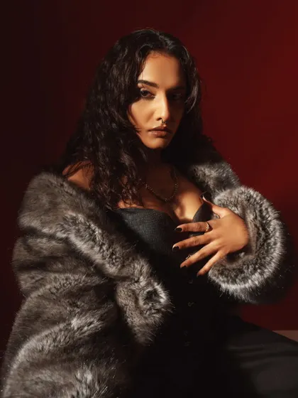A softer, more intimate portrait from the faux fur series. The lighting highlights the model's expression and the texture of the coat.