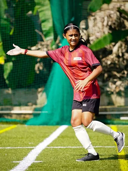 A player directs her teammates on the field, showing leadership and communication during a break in play.