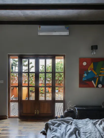 A bedroom with large French doors opening onto a patio, blurring the line between indoors and outdoors.