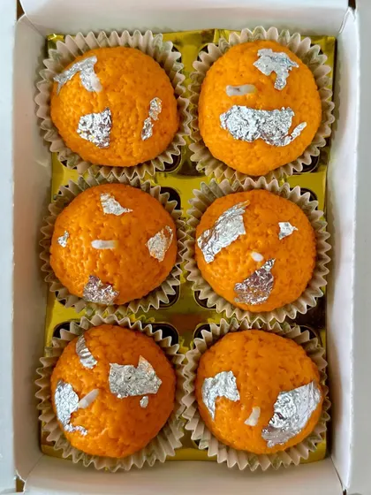 A top-down view of my box of six laddoo candles. Each one is handcrafted from 100% soy wax and finished with edible silver vark for an authentic look.