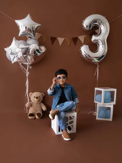 Adjusting his shades like a true star. This playful shot perfectly captures the fun theme of his third birthday photoshoot.