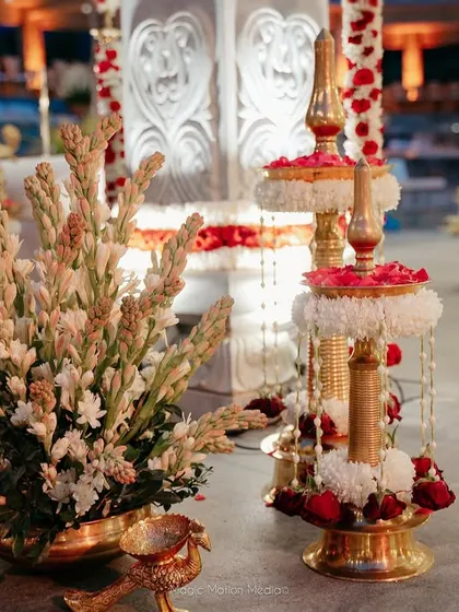 A close-up of the traditional floral arrangements and brass lamps used in the Kerala-style wedding.