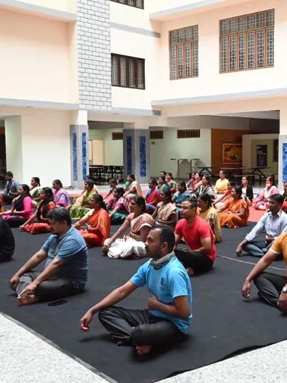 A wide shot of a corporate yoga workshop in progress. Group settings are great for building a sense of community and shared purpose on the mat.