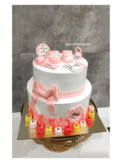 It's a girl! This two tier cake celebrates all the sweet details of a new baby's arrival, with fondant decorations showing the time of birth, weight, and a calendar, all in pretty pink.