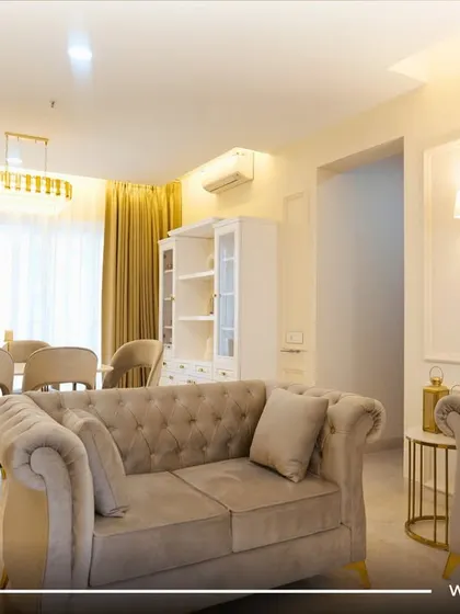 Another angle of the traditional contemporary living room in Pune, showing the seamless flow between the seating area and the dining space, unified by a consistent color palette and elegant finishes.