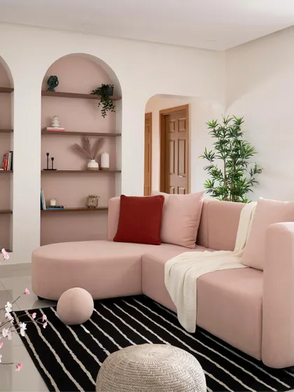 The custom-designed curved sectional sofa is the star of this living room. Paired with a black and white striped rug and soft, round poufs, it emphasizes the home's theme of graceful curves and soft forms.