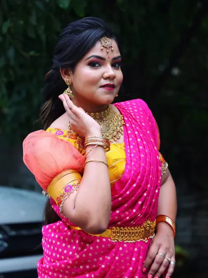A close-up portrait of this modern traditional look. The makeup features a soft smoky eye and glowing skin, perfectly complementing her designer half-saree.