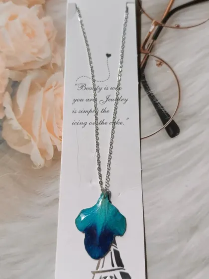 This unique pendant was made from a single, large blue orchid petal. Its natural shape and vibrant color are perfectly captured in the clear resin.