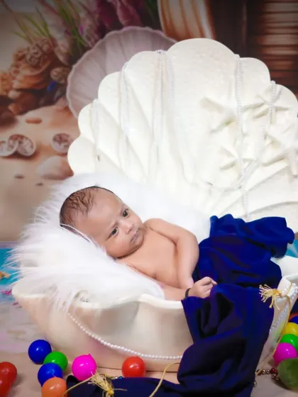 An imaginative newborn shoot with an "under the sea" theme. The baby rests in a large seashell prop, surrounded by ocean-themed toys.