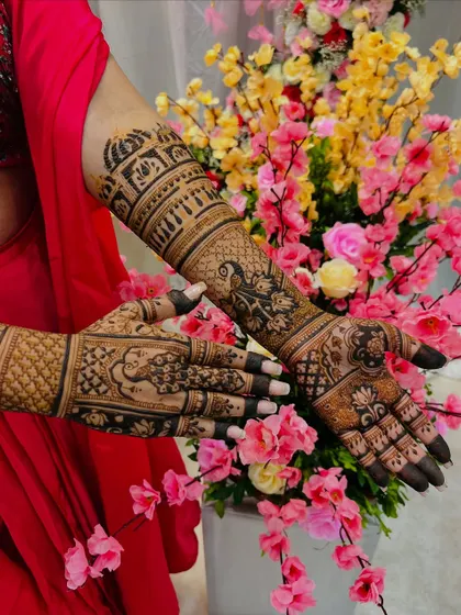 A beautiful shot of an engagement mehendi, featuring architectural dome motifs and peacocks. The design extends gracefully up the arm, creating a look that is both regal and celebratory.
