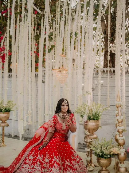 This wide shot captures the grandeur of the wedding decor and the bride's stunning presence. Her makeup was designed to stand out beautifully, even from a distance.