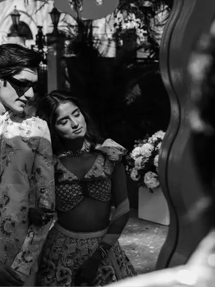 A cool, candid moment of the couple reflected in a wavy mirror. This artistic, black and white shot captures their modern style and connection.