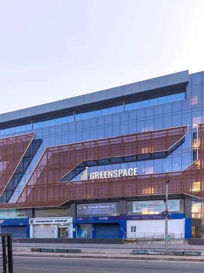 The 'Greenspace' facade is designed to be the building's main highlight. The fluidic metal screen adds a layer of texture and depth to the glass curtain wall, creating a dynamic and modern commercial presence.
