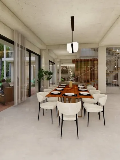 This spacious dining area is flanked by a wall of sliding glass doors that open to a lush garden. The design allows for an abundance of natural light and the flexibility to create an al fresco dining experience.