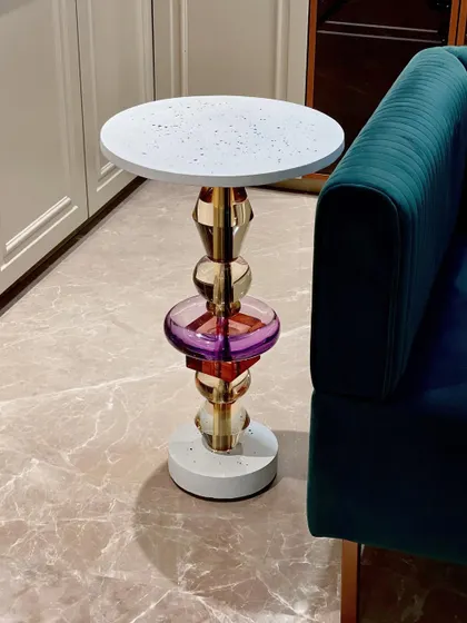 Meet "Floss," our handmade accent table inspired by the Memphis design movement. It features a unique leg made of stacked acrylic and metal forms, topped with a minimal white terrazzo surface, creating a bold pop of color and shape.