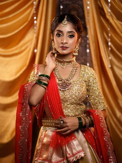 A confident and poised stance. The entire look, from the makeup to the half-saree, is designed to make the bride feel like royalty.