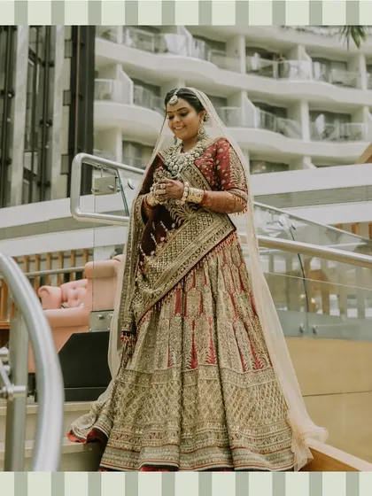 A full-length portrait of the bride, looking absolutely radiant and regal in her richly embroidered wedding lehenga.