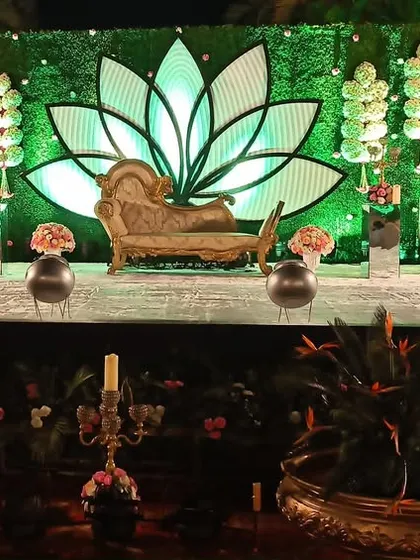 A unique stage design with a large, illuminated lotus motif and a vintage-style chaise lounge, creating a dramatic and artistic focal point.