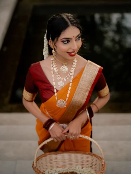 A beautiful shot of the bride holding a basket of flowers. This adds a lovely, soft element to the portrait and complements her traditional attire.