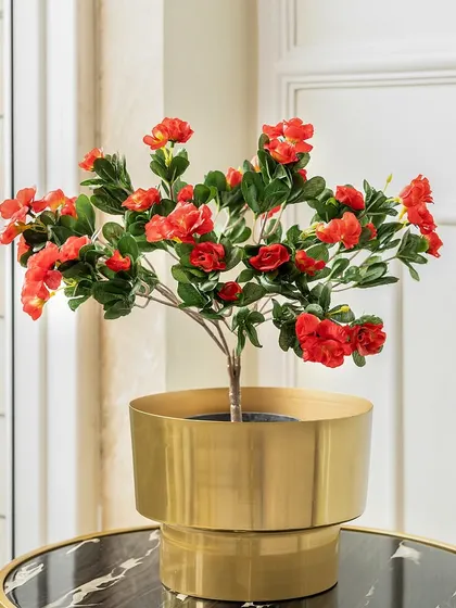 These small, vibrant red artificial spring blooms are perfect for tabletop arrangements. Placed in a modern brass planter, they add a cheerful pop of color to a side table or desk.