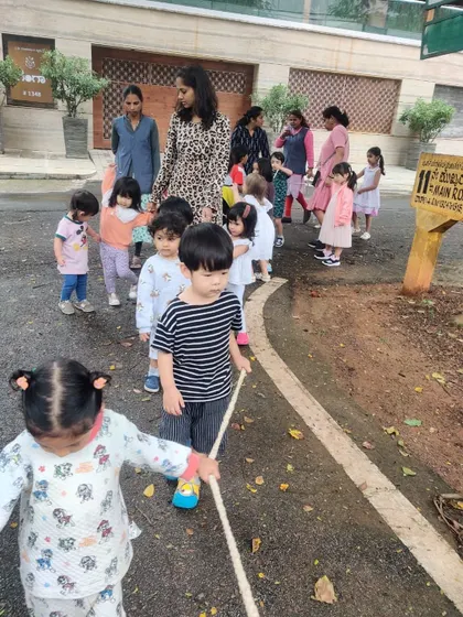 Our students hold onto a rope as they walk through the neighborhood, a safety practice that also builds a sense of unity.